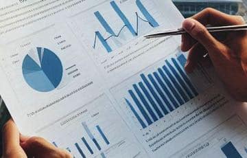 En person med penna i handen håller i en ekonomisk rapport. Bilden ska illustrera någon som läser en rapport om den ekonomiska utvecklingen på spelmarknaden.